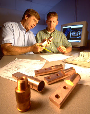 Engineers reviewing drawings with copper parts